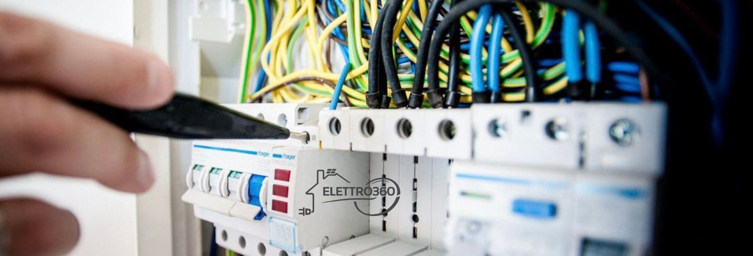 Elettricista a Empoli mentre esegue la revisione di un quadro elettrico con interruttori magnetotermici e cablaggio certificato