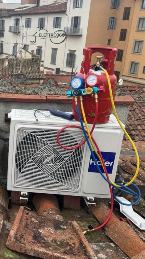 Installazione di unità esterne di climatizzazione e pompa di calore su tetto condominiale, con collegamenti frigoriferi e strumenti professionali.