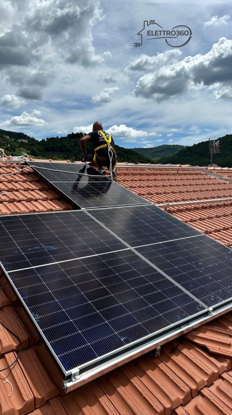 Tecnico specializzato durante l’installazione di pannelli fotovoltaici su tetto residenziale, con sistemi di sicurezza e struttura di supporto.